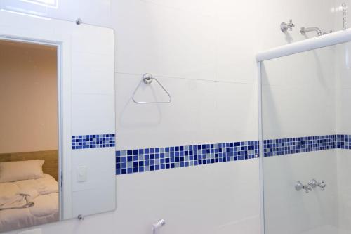ein Bad mit einer Glasdusche und einem Spiegel in der Unterkunft PEDREIRA FLAT HOTEL in Pedreira