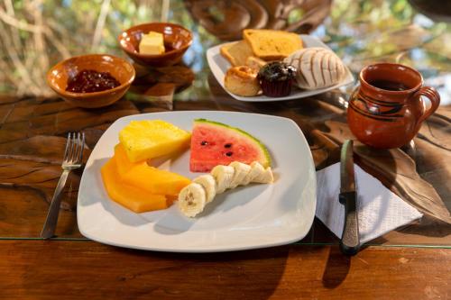 un piatto di cibo con frutta su un tavolo di Villa Maya - Glamping - Natural Reserve a Cozumel