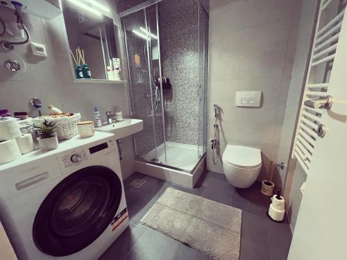 a bathroom with a washing machine and a shower at Ski, cocoa & novel apartment Bjelašnica, garage & ski room in Bjelašnica