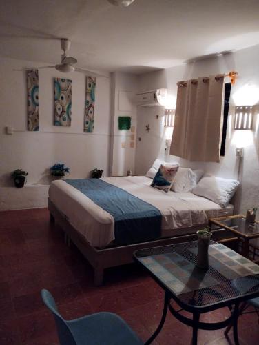 a bedroom with a large bed and a table at San Miguel 2 in Cozumel