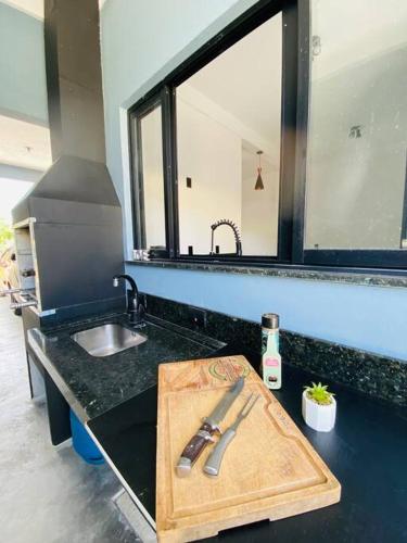 a kitchen counter with a cutting board and a knife at Casa em Bombinhas in Bombinhas