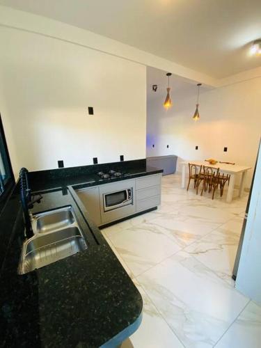 a kitchen with a sink and a counter top at Casa em Bombinhas in Bombinhas