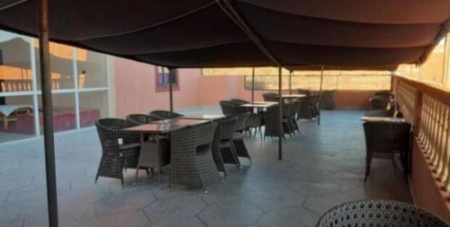 uma sala de jantar com mesas e cadeiras debaixo de um guarda-sol em Hôtel Kasbah Telouet em Telouet