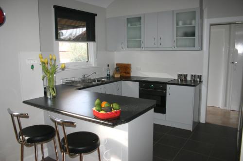 a kitchen with a bowl of fruit on a counter at Banksia Cottage in Albury