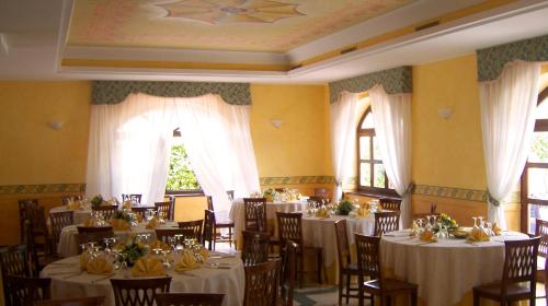 ein Esszimmer mit Tischen und Stühlen mit weißem Tischtuch in der Unterkunft Hotel Del Sole in Sora