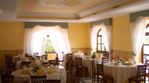 una sala da pranzo con tavoli e sedie con tovaglia bianca di Hotel Del Sole a Sora