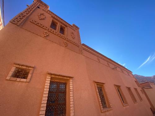 a building with a clock tower on top of it at Tafsut dades guesthouse stay with locals in Tamellalt