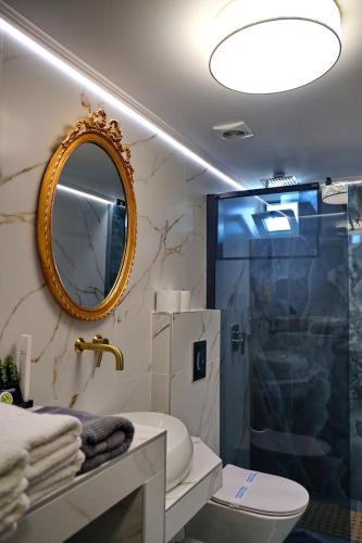 a bathroom with a shower and a toilet and a mirror at Vip Lepanto Castle Suites in Nafpaktos