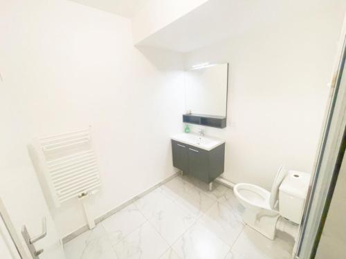 uma casa de banho com um WC, um lavatório e um espelho. em Cosy, simple, centrale, easy transport em Asnières-sur-Seine