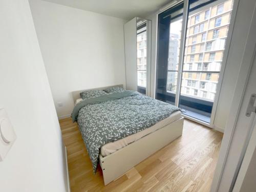 um quarto com uma cama e uma grande janela em Cosy, simple, centrale, easy transport em Asnières-sur-Seine