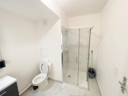 une salle de bain blanche avec douche et toilettes dans l'établissement Cosy, simple, centrale, easy transport, à Asnières-sur-Seine