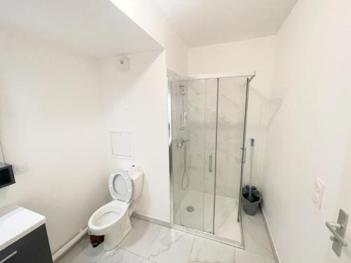 uma casa de banho branca com um chuveiro e um WC. em Cosy, simple, centrale, easy transport em Asnières-sur-Seine