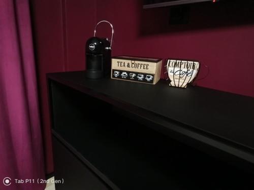 Eine schwarze Kommode mit zwei Tassen drauf. in der Unterkunft Blu room in Taranto
