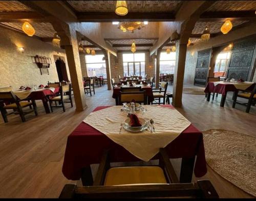 a dining room with a table and chairs in a restaurant at كعب غزال in Merzouga