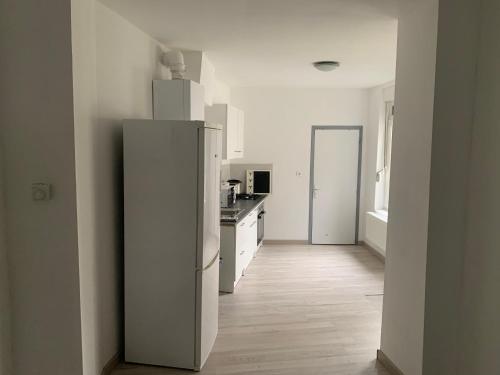 eine Küche mit einem weißen Kühlschrank im Zimmer in der Unterkunft Logement entier 100m2 in Sin-le-Noble