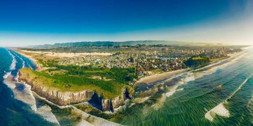 an aerial view of a city next to the ocean at Pousada House Sol & Praia in Torres