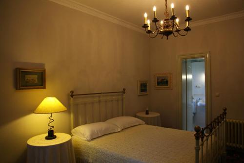 a bedroom with a bed with a lamp and a chandelier at Villa Themistokli in Korçë