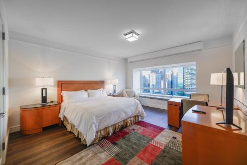 a bedroom with a bed and a desk and a window at Amazing Four Seasons Resort With Great View in Miami