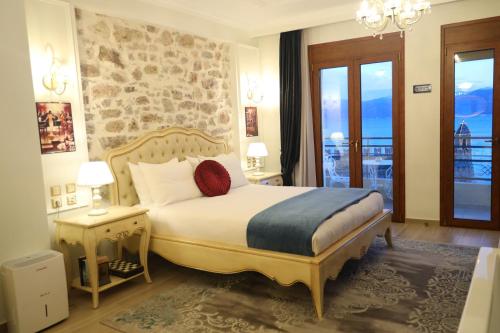 a bedroom with a large bed and a balcony at Vip Lepanto Port Suites in Nafpaktos