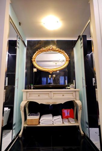 a bathroom with a vanity with a mirror and towels at Vip Lepanto Port Suites in Nafpaktos