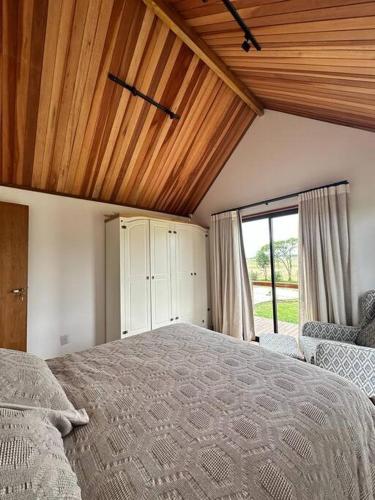 a bedroom with a large bed with a wooden ceiling at Cabanas Purunã in Balsa Nova