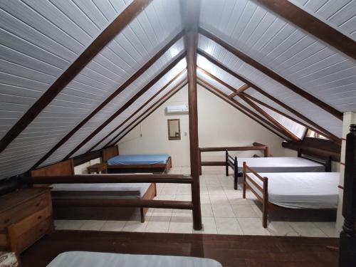 um quarto no sótão com 4 camas e um tecto em Chalé Carvalho - Azul em Itapoá
