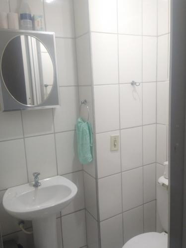 uma casa de banho com um lavatório, um espelho e um WC. em 2 quadras do mar em Vila Velha