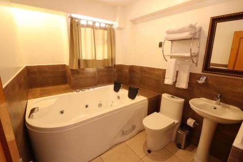 łazienka z wanną, toaletą i umywalką w obiekcie El SOL HOTEL - URUBAMBA w mieście Urubamba