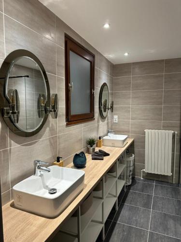 une salle de bain avec deux lavabos et un miroir dans l'établissement Maison Confort Stationnement Privatif 6 pers, à Échirolles
