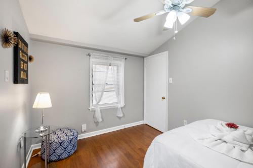 Un dormitorio blanco con una cama y un ventilador de techo. en Contemporary 1br Urban Retreat, en Filadelfia