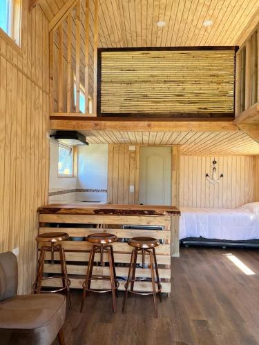 Pokój z barem ze stołkami i łóżkiem w obiekcie Dalcahue Lodge 
