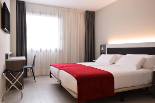 a bedroom with a large bed with a red blanket at Santa Limbania Boutique Hotel in Santa Cruz de la Sierra
