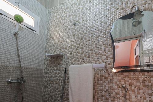 La salle de bains est pourvue d'une douche avec un miroir et un lavabo. dans l'établissement Chambre familiale, à Aït Mouloud