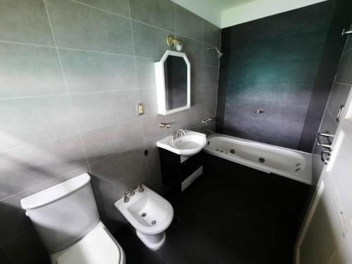 a bathroom with a toilet and a sink and a bath tub at MODERNA x 11 Pax in Mendoza