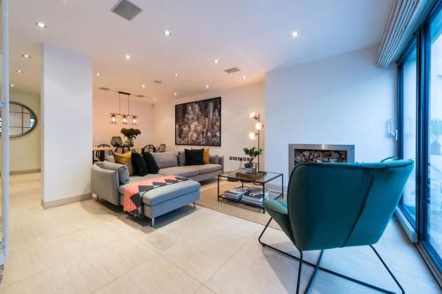 uma sala de estar com um sofá e cadeiras e uma lareira em Spectacular Mews House in Holland Park em Londres
