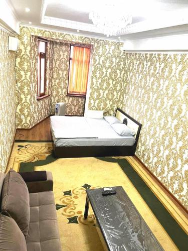 a bedroom with a bed and a couch in it at 1-room apartment in Dushanbe