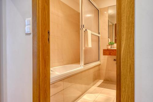 y baño con ducha y bañera. en Funchal Atrium, a Home in Madeira, en Funchal