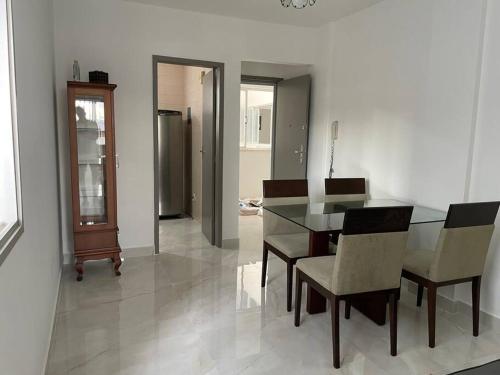 a dining room with a glass table and chairs at Quarto e sala 100 mts da praia in Guarapari