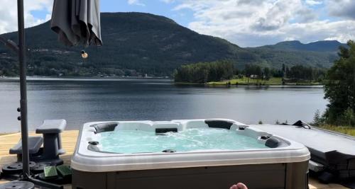 una vasca idromassaggio su una terrazza con vista sul lago di Lakefront Villa, exclusive leisure property near Vrådal Golf, Straand Summerland & Panorama Ski center a Vrådal