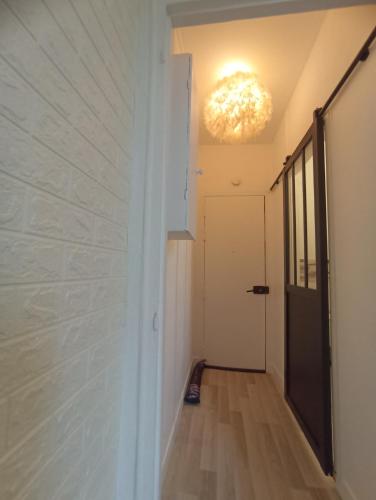un couloir avec un mur blanc et un éclairage dans l'établissement Grand studio cosy calme, à Clichy-sous-Bois