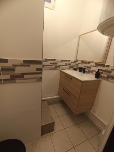 La salle de bains est pourvue d'un lavabo et d'un miroir. dans l'établissement Grand studio cosy calme, à Clichy-sous-Bois