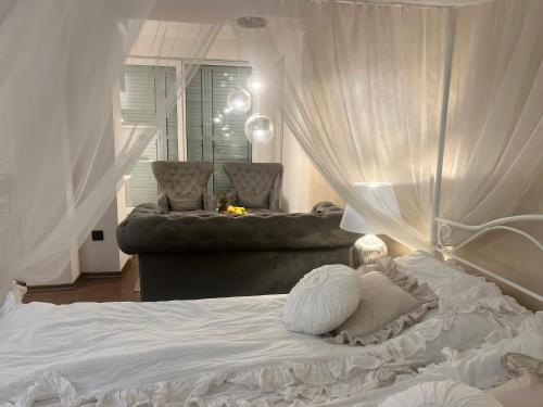 a bedroom with a white bed with a canopy at Fleur de Lys in Kikinda