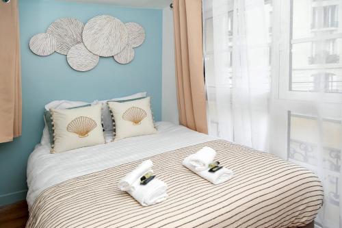 un lit avec deux serviettes dessus dans l'établissement Nets Inn Apartment - Gare de Lyon, à Paris