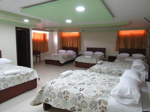 una habitación de hotel con 3 camas. en KORPAWASY, en Ipiales