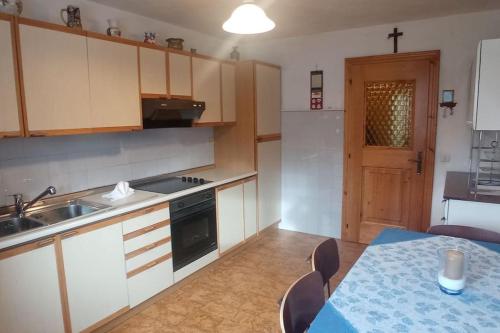 a kitchen with a sink and a table with chairs at Panorama mozzafiato in Cortina dʼAmpezzo
