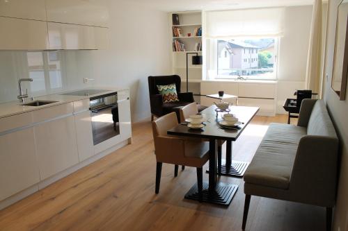 a kitchen and living room with a table and chairs at Residence Apartment in Vaduz