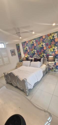 ein Schlafzimmer mit einem großen Bett und einem Gemälde an der Wand in der Unterkunft Greystone Mansion in Accra