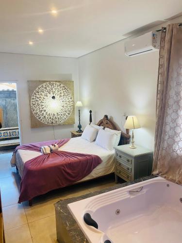 a bedroom with a large bed and a bath tub at POUSADA CHARLOTTE in Tiradentes