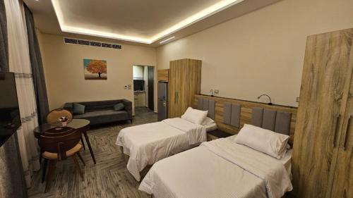 Luxury Accommodation في Sheikh Zayed: غرفة فندقية بسريرين واريكة