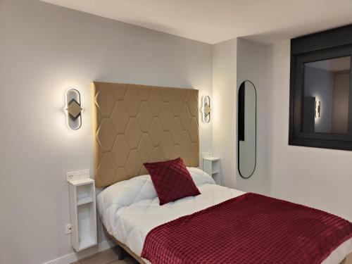 a bedroom with a large bed with a red pillow at Apartamentos Centro Oviedo Caveda in Oviedo